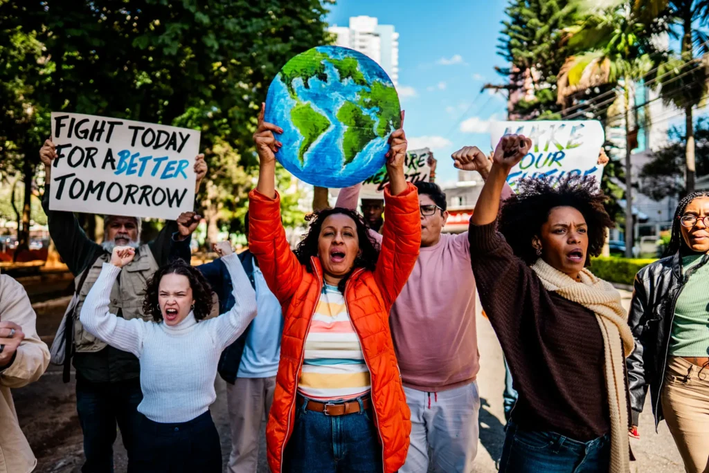 Protesters holding signs and a globe model advocating for climate action.